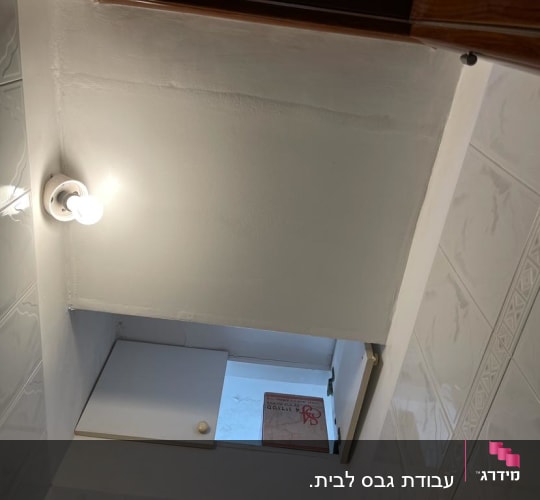 תקרה מגבס עם מנורה דולקת וחיפוי קיר